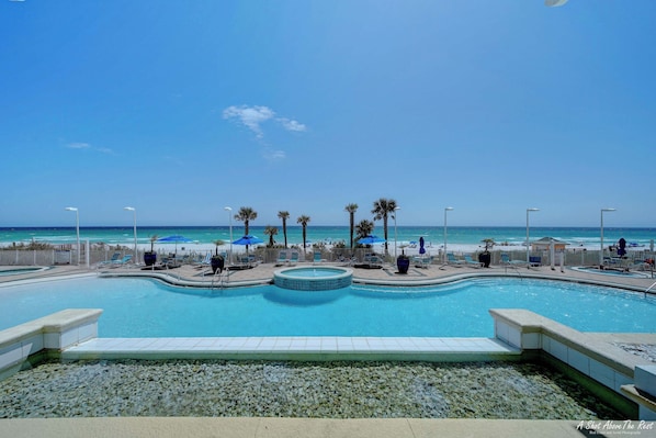 A swimming pool with a view of the beach and ocean.