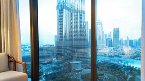 Vista desde una ventana de un edificio moderno de gran altura, con un rascacielos destacado y un río en primer plano.