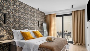 A modern hotel room with a large bed, two mustard pillows, a throw blanket, a bedside table, and a view of the outside through a sliding glass door. - NEW Seaview Villa Gabriel with private heated pool and a Hot-tub (Stanici)