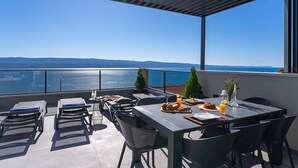 A terrace with a table set for breakfast, overlooking a body of water and distant hills. - NEW Seaview Villa Gabriel with private heated pool and a Hot-tub (Stanici)