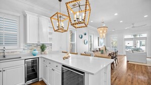 A modern kitchen with white cabinetry, a central island, and pendant lighting.