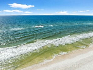 Ein Strand mit klarem, blauem Wasser und einem sandigen Ufer.