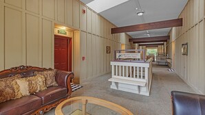 A hotel lobby with a wooden bench, a leather sofa, and a glass-top table. - 3rd Floor Front Side Corner Penthouse Suite - 301 by Grand Wood Suites (Nashville)
