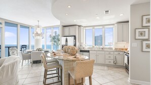 A spacious kitchen with a central island, large windows, and a view of the ocean. - Lagoon Tower 1301 3 Bedroom Condo (Gulf Shores)