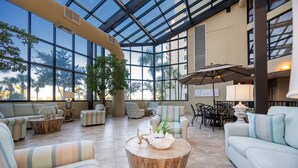 Amplio espacio interior con grandes ventanales, asientos cómodos y una mesa de centro.