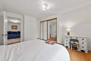 A bedroom with a large bed, a dresser, and a mirror. - Morrill Modern Retreat – Desirable Marion Village! (Columbus)