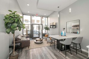A modern interior with a dining area, seating, and a large window. - Findlay Market Suites – 4 in 1! (Cincinnati)