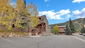 A lodge with a wooden exterior, stone steps, and a parking lot.