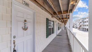 A corridor with a white door labeled "7103" and a wooden ceiling.