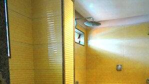 A small, compact bathroom with a toilet, sink, and shower. - Sri Brundavan Grand Inn (Anakapalle)