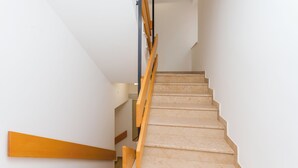 A staircase with wooden handrails and beige steps.