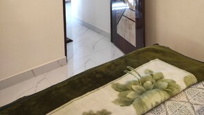 Une pièce avec une porte donnant sur un autre espace, une horloge au mur et une prise de courant.