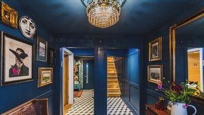 A hallway with a checkered floor, a chandelier, framed artwork, and a staircase leading to another room. - The Pilchard Press, The Pilchard Press on Harbourside in Mevagissey Village with FREE Parking (Saint Austell)