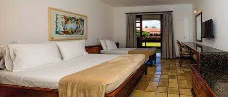 A hotel room with a large bed, a smaller bed, a desk, and a TV.