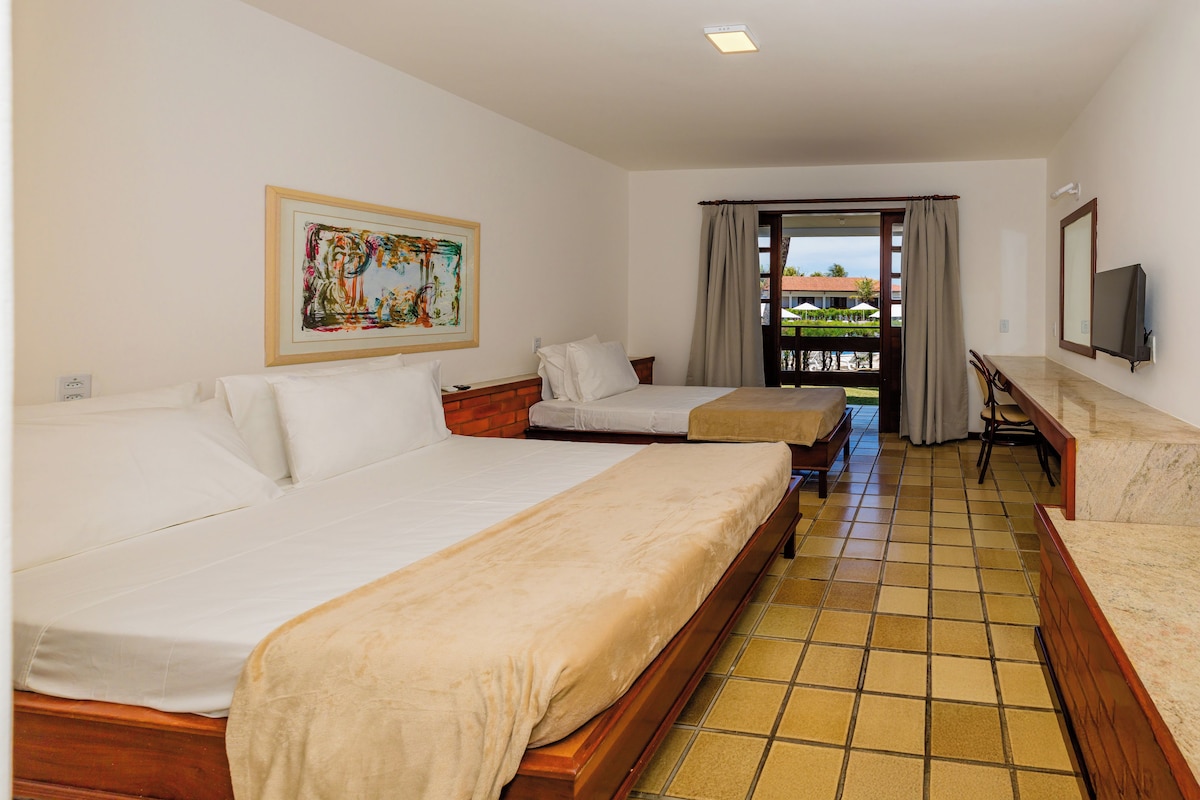 Ein Hotelzimmer mit zwei Betten, einem Fernseher und einem Bild an der Wand.