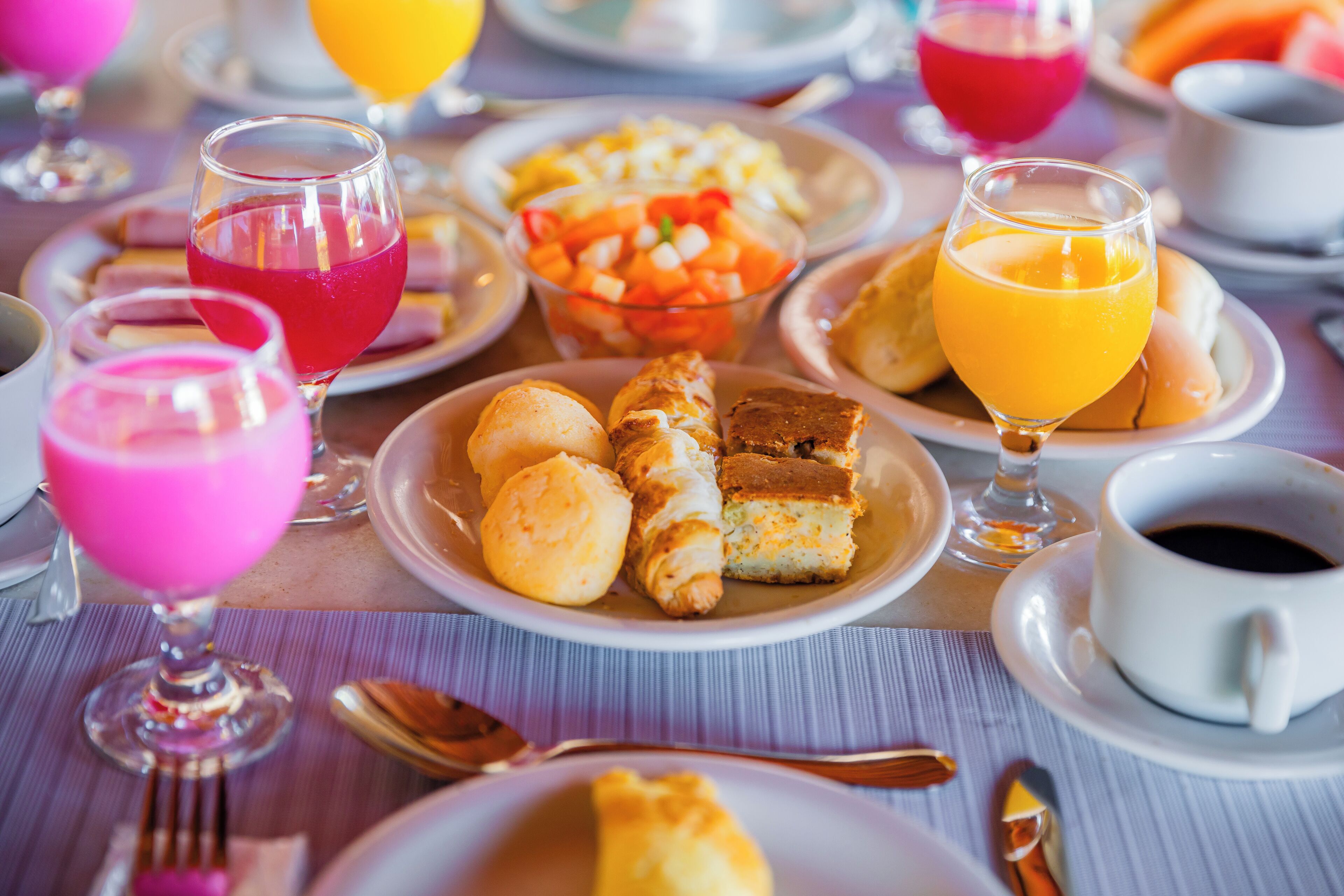A table set with various breakfast items including pastries, fruits, and beverages.