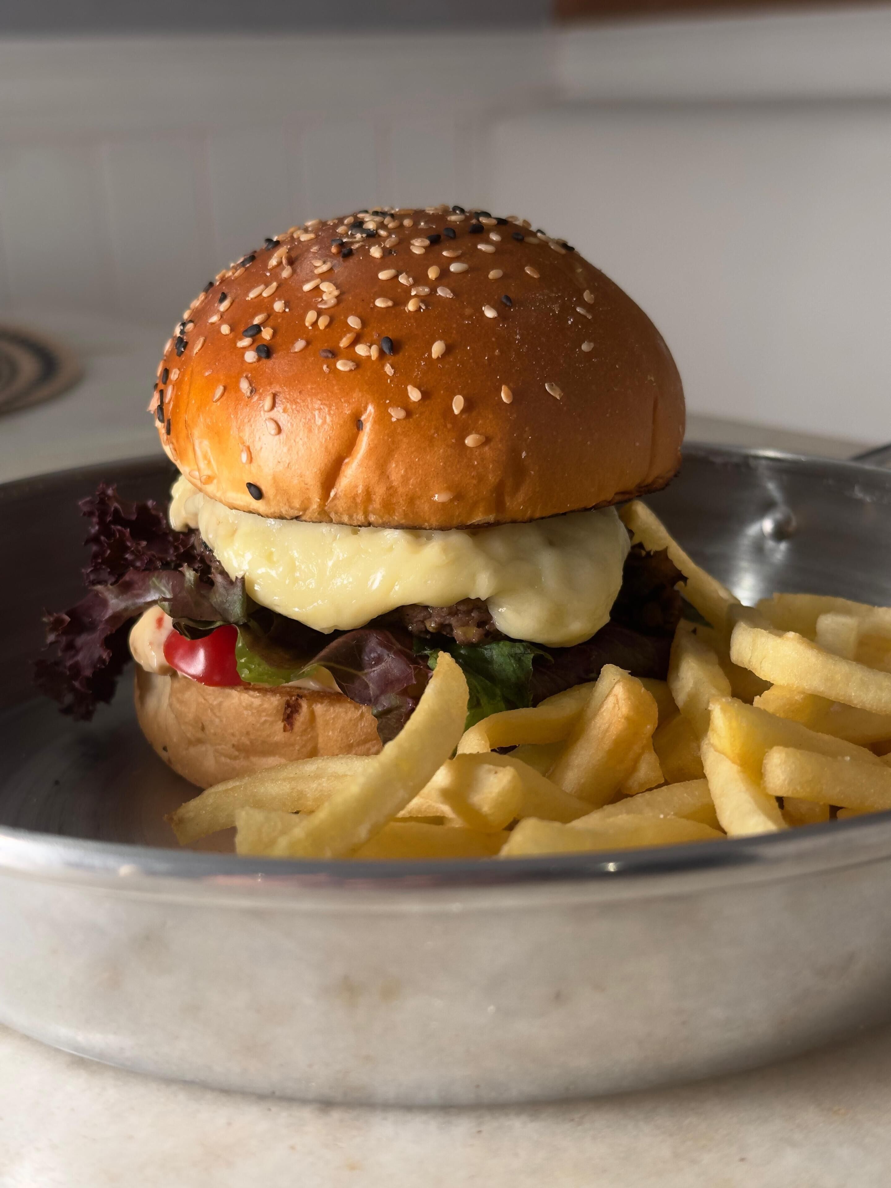 Ein Burger mit Pommes auf einem Teller.