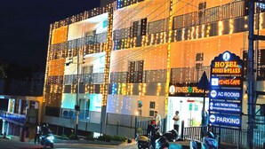 Un hotel con varios balcones, un cartel que dice "Hotel Pines & Peaks" y un letrero que anuncia "Pines Cafe".