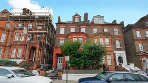 A row of terraced houses with brick facades, some under construction with scaffolding. - Elegant flat in trendy Hampstead - Pass the Keys (London)