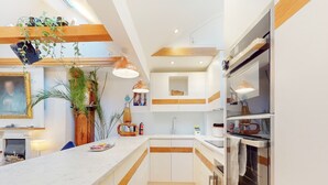 A modern kitchen with a marble countertop, wooden accents, and built-in appliances. - Elegant flat in trendy Hampstead - Pass the Keys (London)