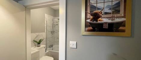 A bathroom with a shower, toilet, and sink.