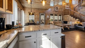A spacious kitchen with a marble countertop, wooden cabinets, and pendant lighting. - SkyHorse Lodge (direct access to national forest) 3 bedroom, 3.5 bath (Broken Bow)