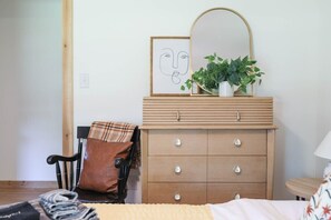 A bedroom with a bed, a wooden dresser with drawers, a chair, a mirror, a framed picture, and a potted plant. - Sycamore Shade: 151 House, HOT TUB, Mountain Views (Afton)