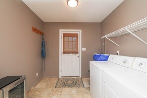 A laundry room with a washing machine, dryer, and a drying rack.