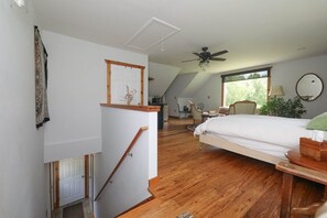 A bedroom with a bed, a chair, a desk, a window, and a ceiling fan. - Blue Rivers Loft on the Brew Ridge Trail (Afton)