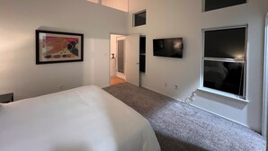 A bedroom with a bed, a ceiling fan, a framed picture, a television, and a window. - Charming 3-bedroom house in central Austin (Austin)