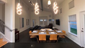 A spacious dining area with a long wooden table set for six, surrounded by chairs. - Charming 3-bedroom house in central Austin (Austin)