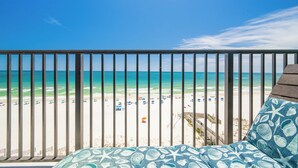 Un balcon avec vue sur une plage et l’océan.
