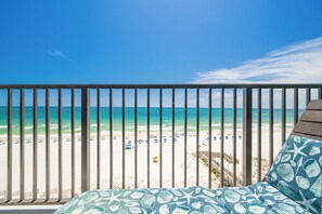 A balcony with a view of a beach and ocean.