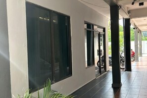 A corridor with a large window, a door, and a motorcycle parked outside. - RHU DORMITORY LANGKAWI (Langkawi)
