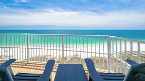 A balcony with a view of a beach and ocean.