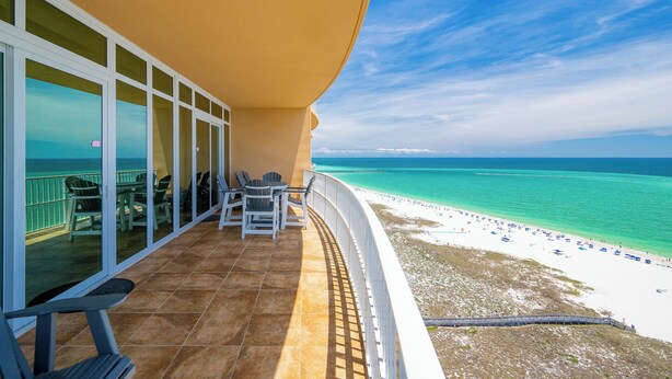 A balcony with a view of a beach and ocean.