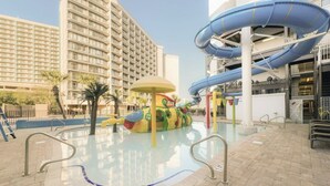 Un área de piscina con tobogán y un parque infantil.
