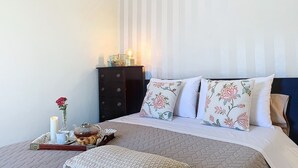 A neatly arranged bedroom with a bed, pillows, a bedside table, and a dresser. - Sevenhouse by Atlantic Holiday (Machico)