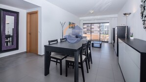 A modern kitchen with a dining area, a large window, and a view of the city. - 1 Bedroom apartment Paraiso Sol da Rocha (Portimão)