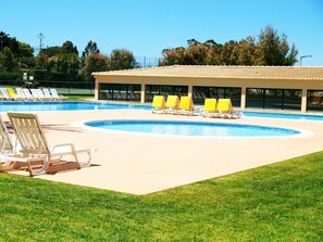 Relax by the clear pool surrounded by a deck and lounge chairs.