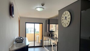 A modern kitchen with a large clock, a toaster, and a view to the outside. - 3 Bedroom apartment Paraiso Sol da Rocha (Portimão)