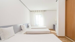 A hotel room with two single beds, a wooden wardrobe, and a window with sheer curtains. - 3 Bedroom apartment Paraiso Sol da Rocha (Portimão)