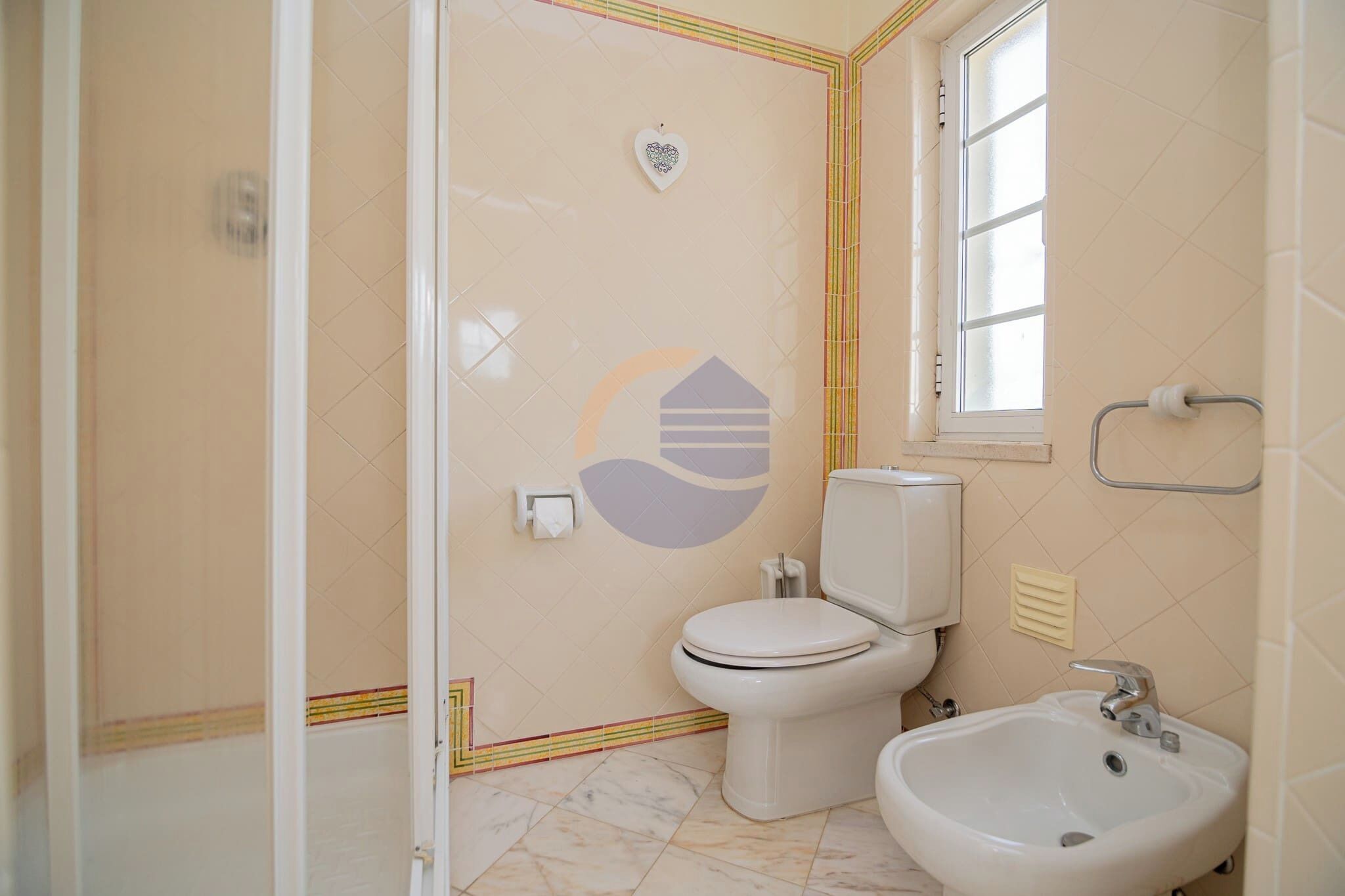 A bathroom with a toilet, sink, and shower.