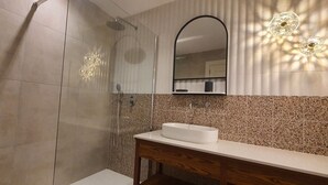 A modern bathroom with a shower, a sink, and a mirror. - Capital Central Suites No2 - Peppa (Valletta, Malta,)
