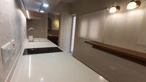 A modern kitchen with a countertop, sink, and a window with curtains. - Capital Central Suites No2 - Peppa (Valletta, Malta,)