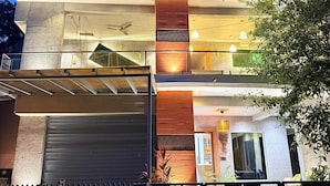 Un edificio moderno de varios pisos, con balcones, ventanas amplias y un portón de garaje.