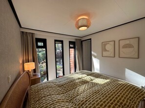 Relax in a stylish room with a large bed, ceiling light, and artwork.