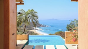 Una piscina infinita con vistas al océano y la playa.