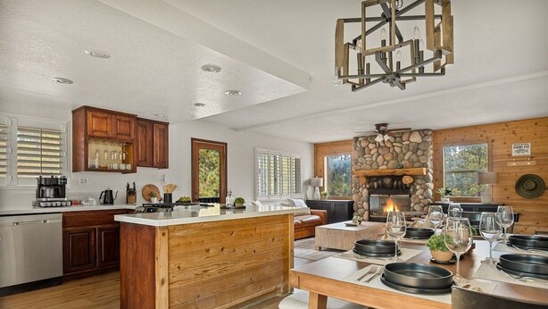 Una cocina amplia con una isla central, armarios de madera y una chimenea de piedra.