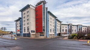 A multi-story hotel with a modern architectural design, featuring a mix of red, blue, and beige colors. - For Students Only Mealmarket Exchange in Aberdeen (Aberdeen)